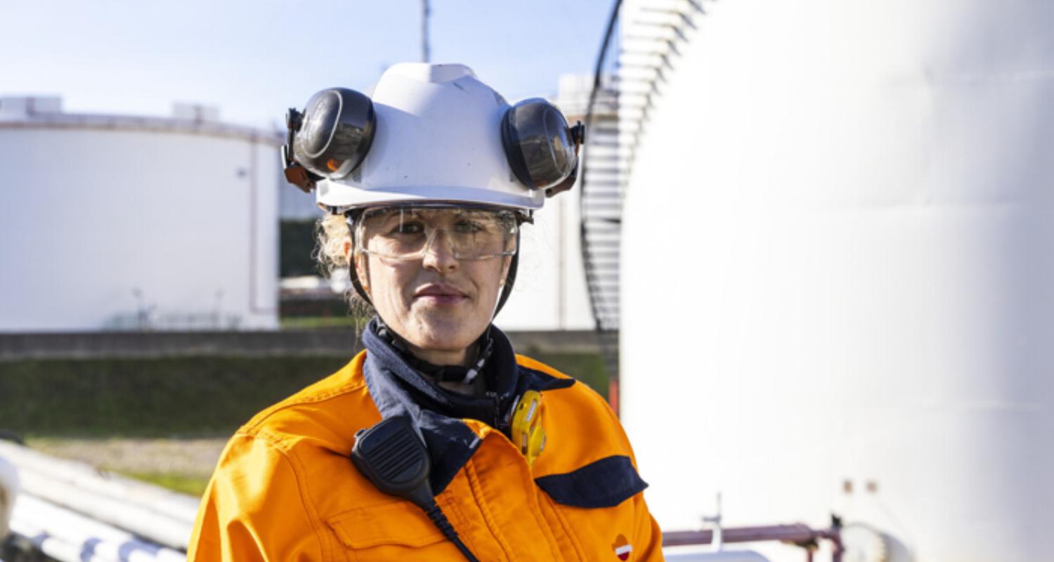 Primer plano de operaria con casco y gafas.